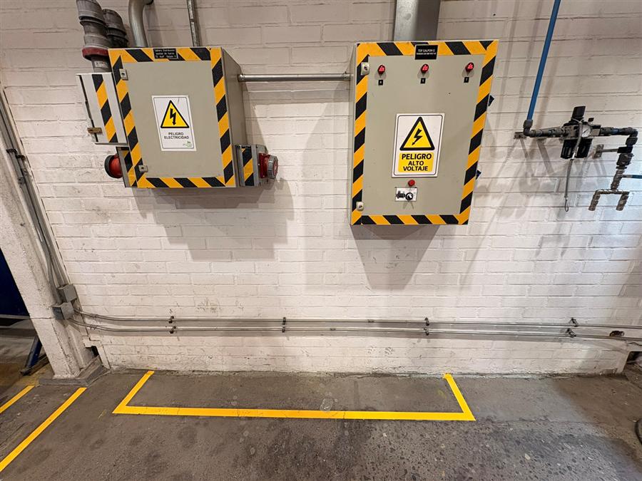 Tableros eléctricos señalizados con advertencia de alto voltaje y demarcación de piso